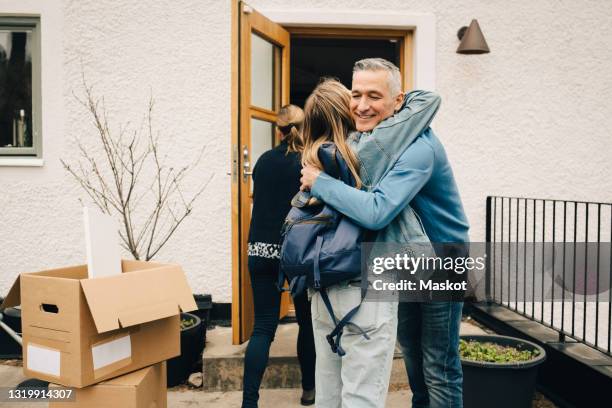happy father hugging daughter while standing at back yard - filhos adultos - fotografias e filmes do acervo