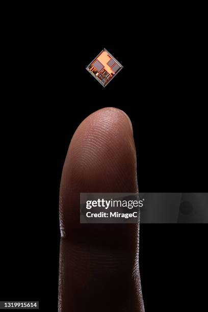 tiny computer chip levitation on top of finger - chips stock-fotos und bilder