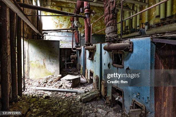 old heating boilers in an abandoned building - broken pipe stockfoto's en -beelden