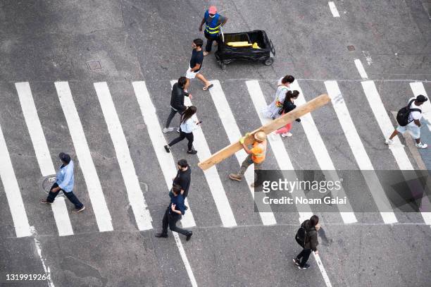 People cross the street in Kips Bay on May 24, 2021 in New York City. On May 19, all pandemic restrictions, including mask mandates, social...