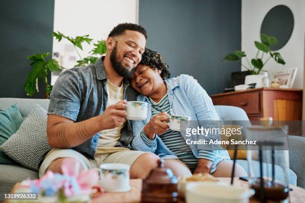 一個年輕人在家的沙發上和他年邁的親戚喝咖啡的鏡頭 - 茶 熱飲 個照片及圖片檔