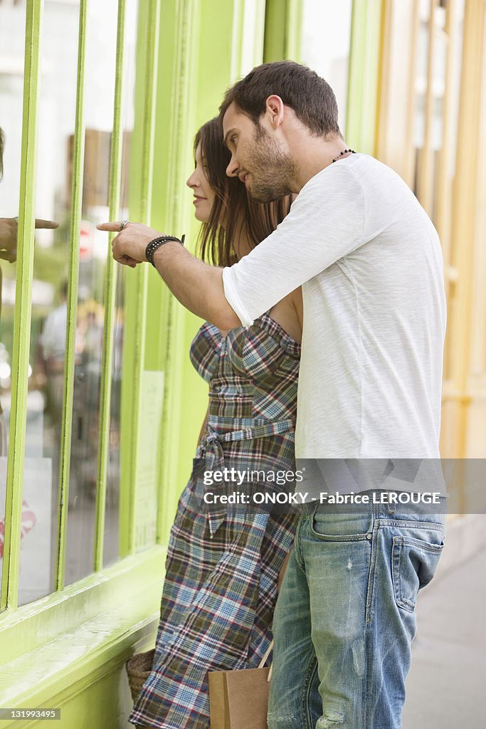 Couple looking at the display window of a store, Paris, Ile-de-France, France