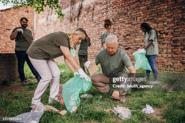 volunteers cleaning park together - initiative stock pictures, royalty-free photos & images