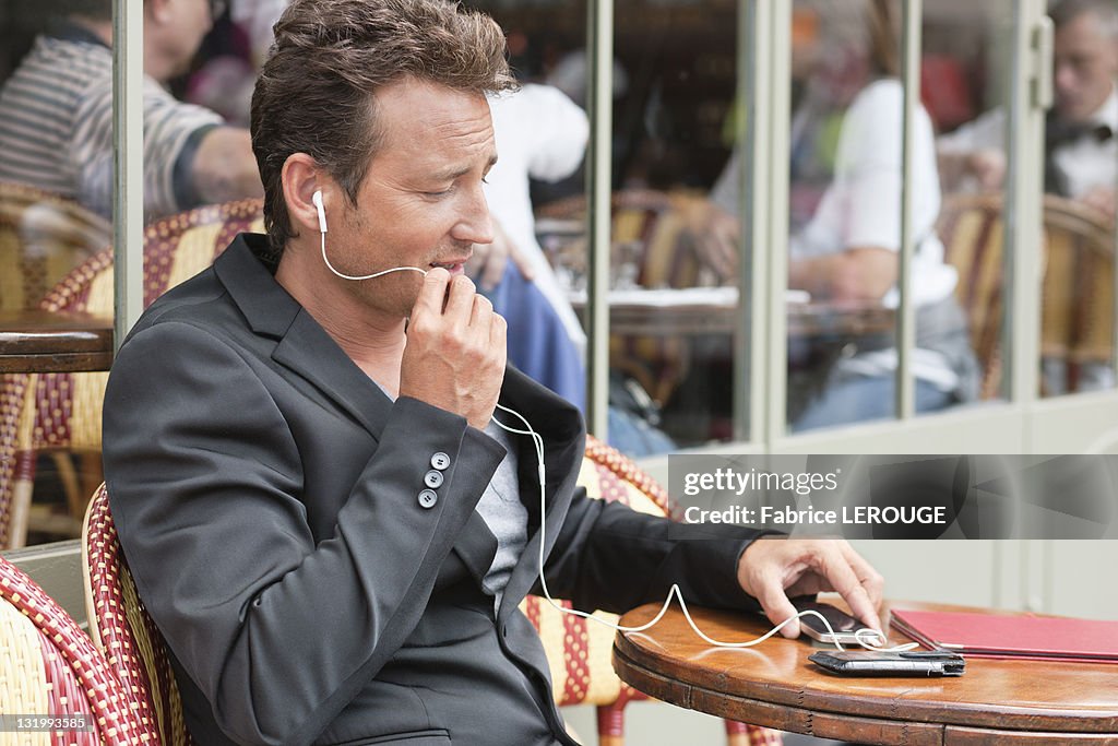 Man talking on a mobile phone in a restaurant, Paris, Ile-de-France, France