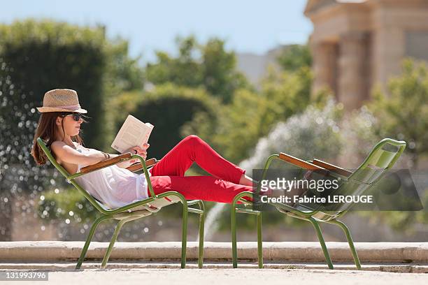 woman sitting in a chair and reading a magazine, bassin octogonal, jardin des tuileries, paris, ile-de-france, france - jardin des tuileries stock pictures, royalty-free photos & images