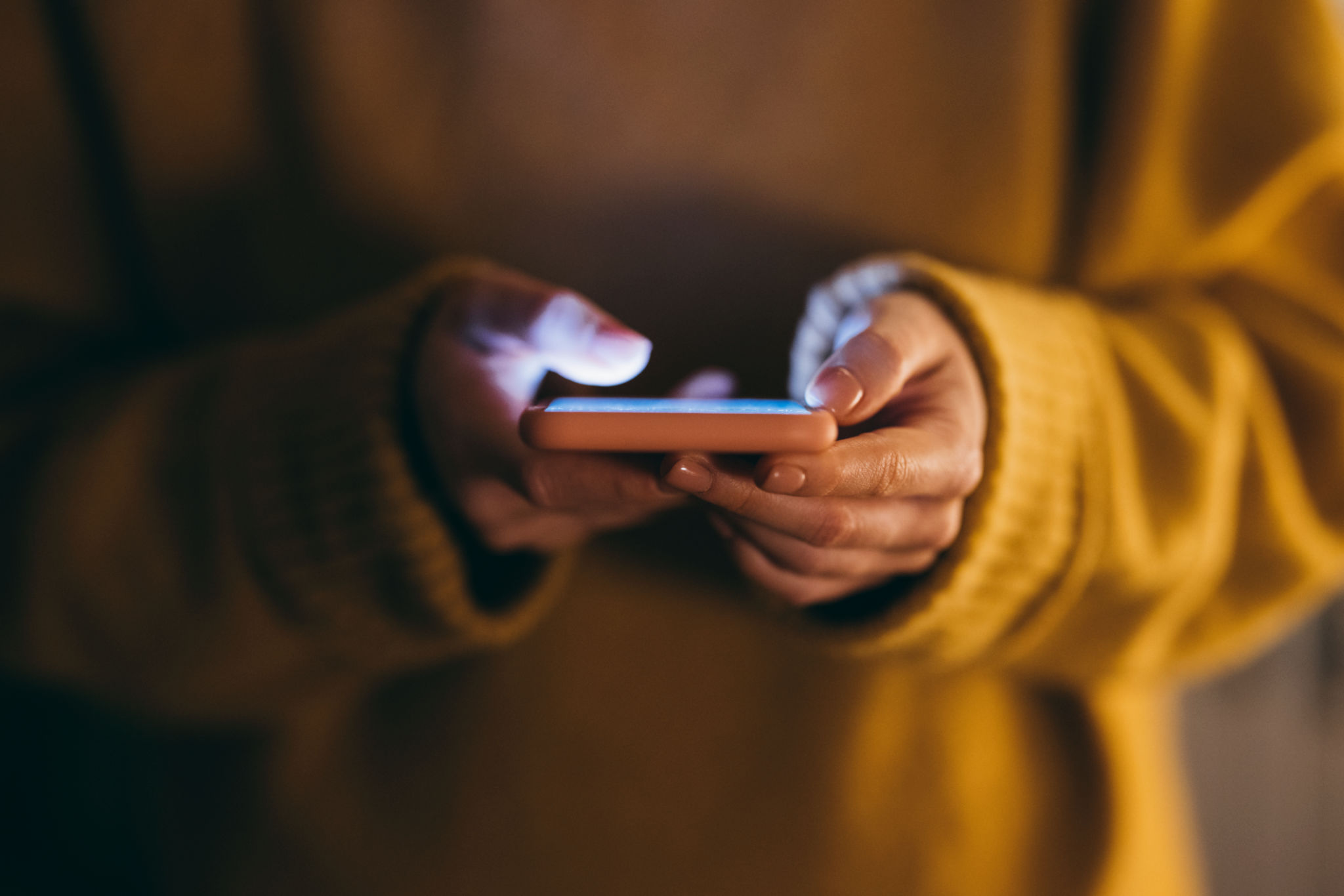 Femme anonyme utilisant un chandail retenant son smartphone Femme anonyme utilisant un chandail retenant son smartphone