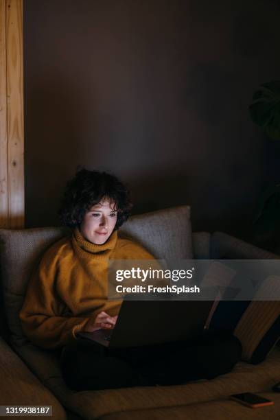 socializar durante la pandemia: feliz joven se une a una videollamada con sus amigos en su computadora - night in fotografías e imágenes de stock