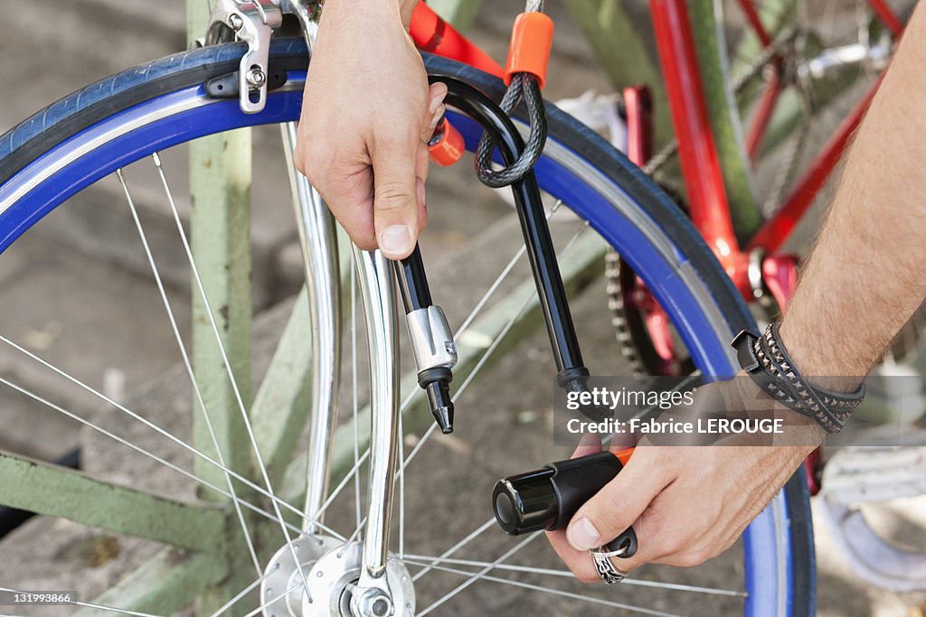 Close-up of a man's hands locking his bicycle, Paris, Ile-de-France, France