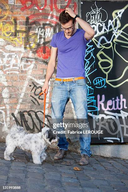 man holding a dog on leash, paris, ile-de-france, france - cacca foto e immagini stock