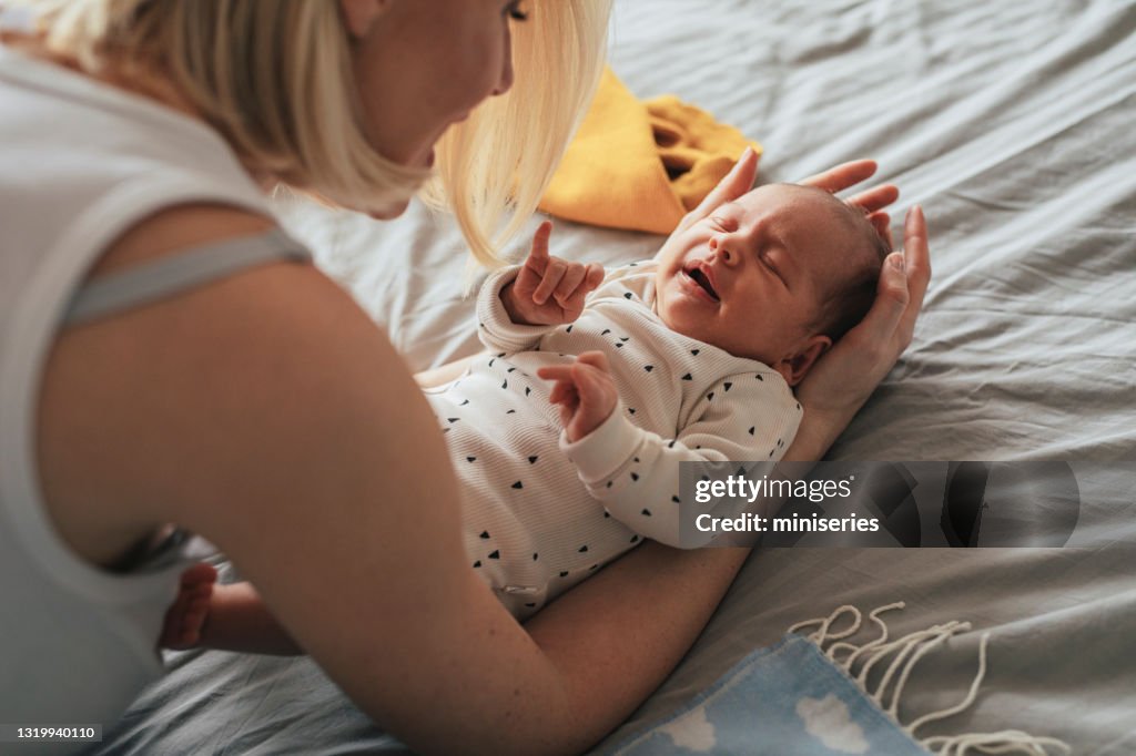 Vínculo com recém-nascido: mãe está segurando seu bebê chorando