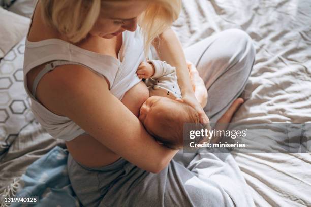 bonding mit neugeborenem: mutter stillt auf schlecht - still stock-fotos und bilder