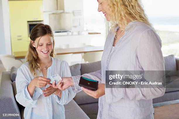 girl taking money from her mother - taschengeld kind stock-fotos und bilder