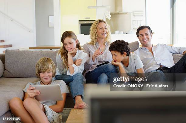 family watching tv together at home - stereotypical stock pictures, royalty-free photos & images