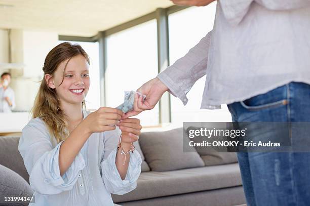 girl taking paper currency from her mother - pocket money stock pictures, royalty-free photos & images