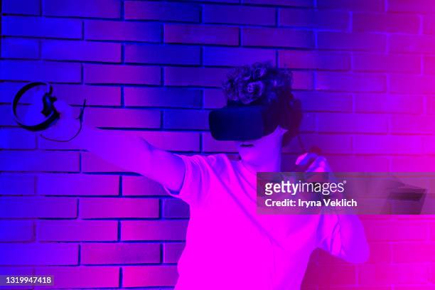 young man or teenager in a white t-shirt wearing virtual reality headset during the vr experience. - casques réalité virtuelle photos et images de collection