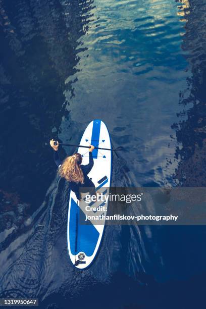 female sup paddle-boarding in ocean - paddleboard stock pictures, royalty-free photos & images