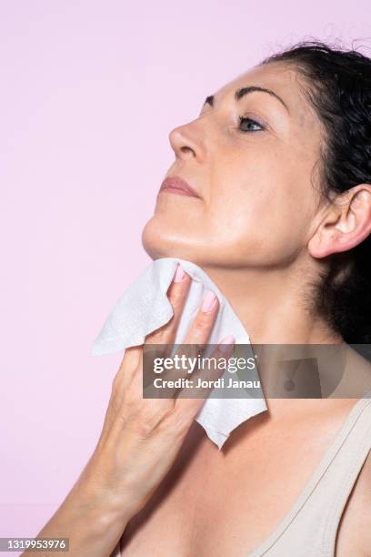 beautiful middle-aged woman removing make-up with a make-up remover wipe - woman make up face wipes not men stock pictures, royalty-free photos & images