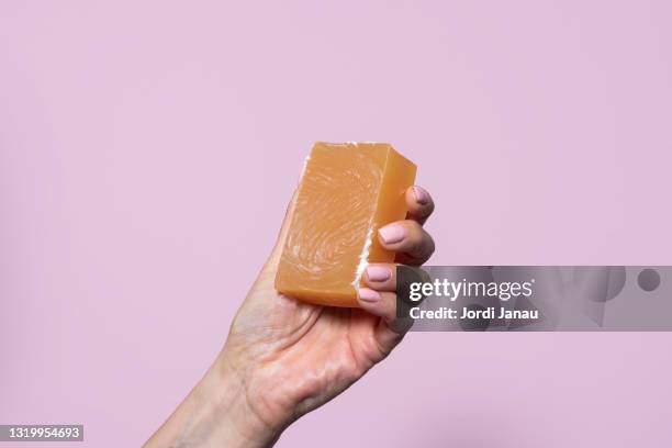 close-up of a hand holding a bar of soap - seifenstück stock-fotos und bilder