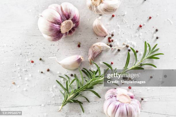 top view of a garlic food concept consisting of: bulbs, cloves, rosemary and various peppers. - onion family stock pictures, royalty-free photos & images