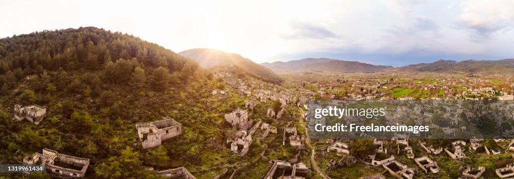 Aerial view looking over an abandoned town on a mountain side at sunrise