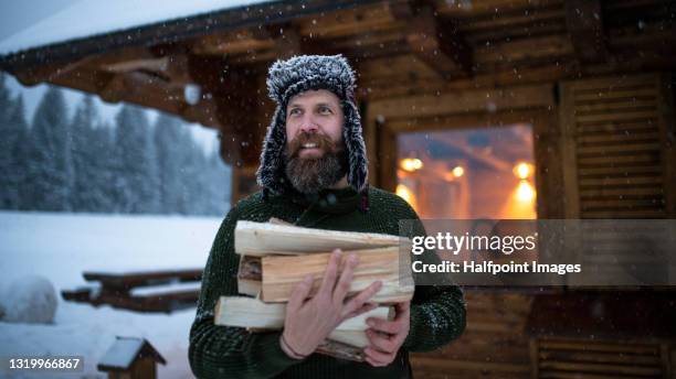 mature man on holiday in snowy winter nature, gathering firewood. - tatras slovakia stock pictures, royalty-free photos & images