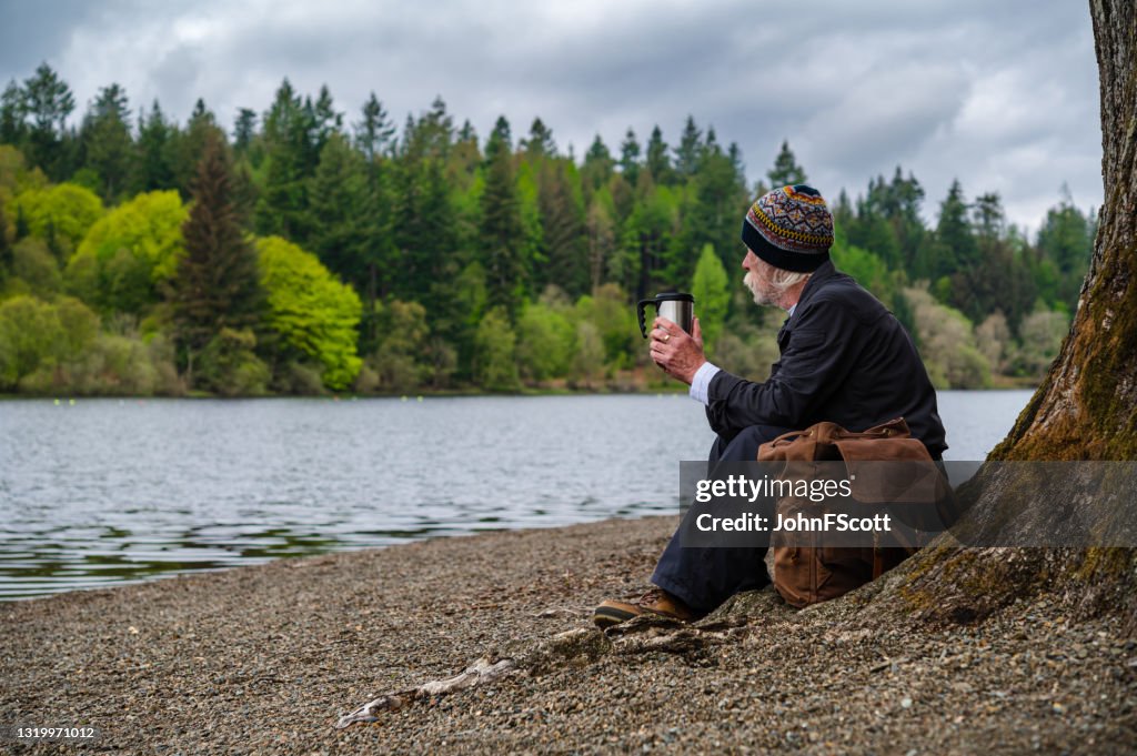 Senior Mann sitzt neben einem Loch