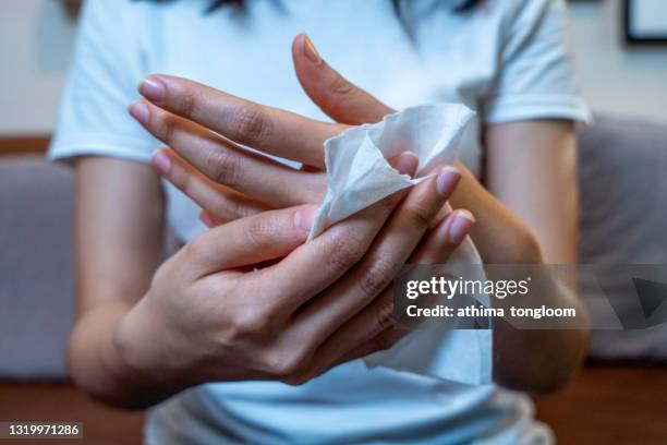 close up hand of asian woman using wet tissue paper wipe cleaning her hands. - clean hands stock pictures, royalty-free photos & images