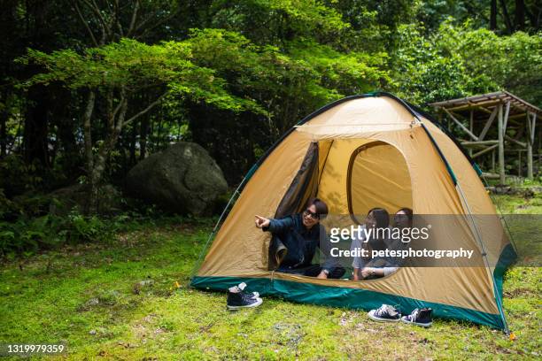 a young family sitting in a tent in a forest - japanese tents stock pictures, royalty-free photos & images