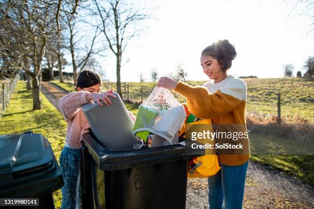 emptying the recycling bin - mixed recycling bin stock pictures, royalty-free photos & images