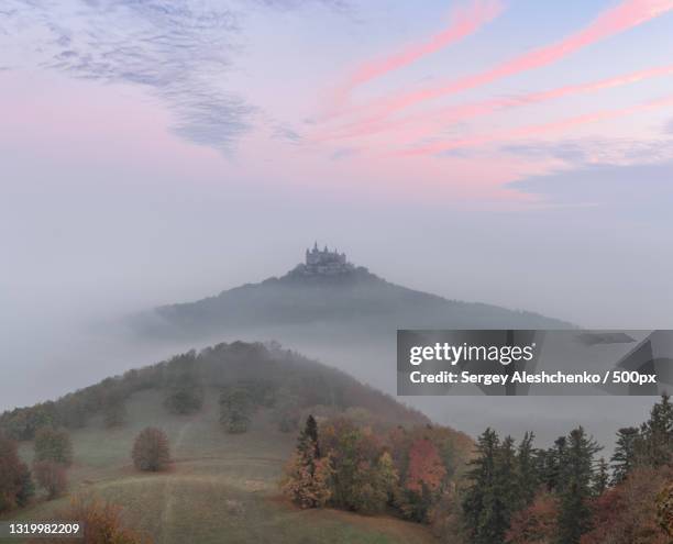 scenic view of landscape against sky during foggy weather,burg hohenzollern,germany - burg hohenzollern stockfoto's en -beelden