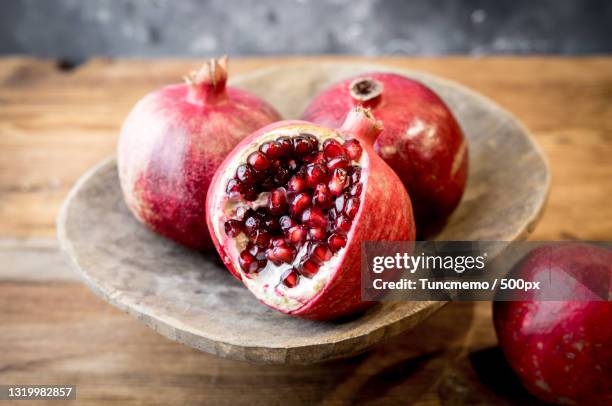 close-up of pomegranates on table - granatapfel stock-fotos und bilder