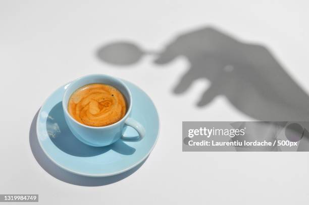 high angle view of coffee cup on table - spoon in hand stock-fotos und bilder