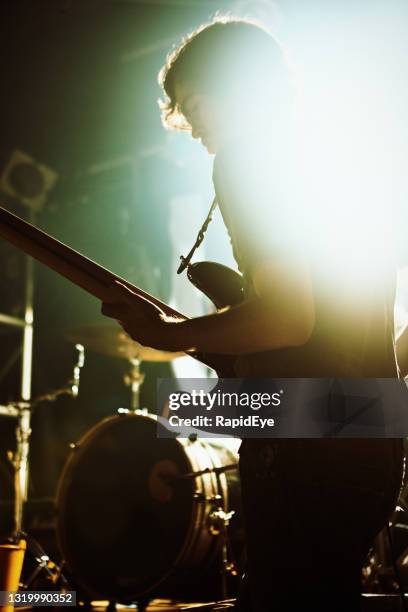 junger mann spielt bei einer rockshow leidenschaftlich bassgitarre auf der bühne - popular music concert stock-fotos und bilder