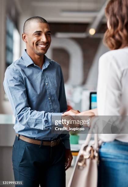 オフィスで女性と握手する若いビジネスマンのショット - happy client meeting ストックフォトと画像