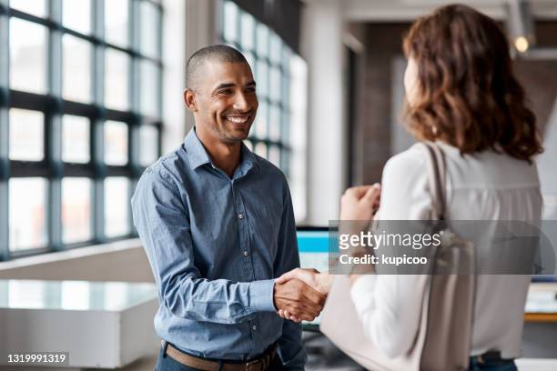 shot of a young businessman shaking hands with a woman in an office - casual clothing stock pictures, royalty-free photos & images
