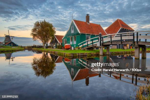 scenic view of lake by buildings against sky,zaanse schans,zaandam,netherlands - zaandam stock pictures, royalty-free photos & images