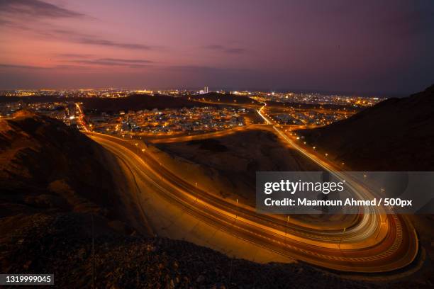 high angle view of illuminated city against sky at night,muscat,oman - oman muscat stock pictures, royalty-free photos & images