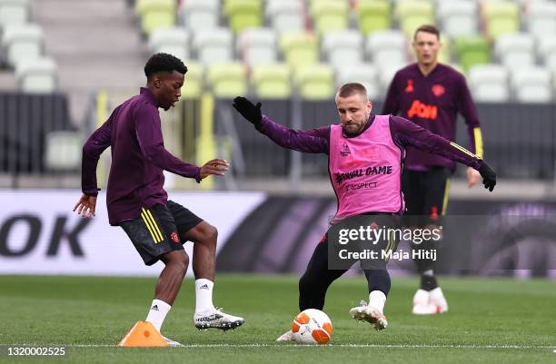 Anthony Elanga of Manchester United makes a pass whilst under pressure from team mate Luke Shaw during the Manchester United Training Session ahead...