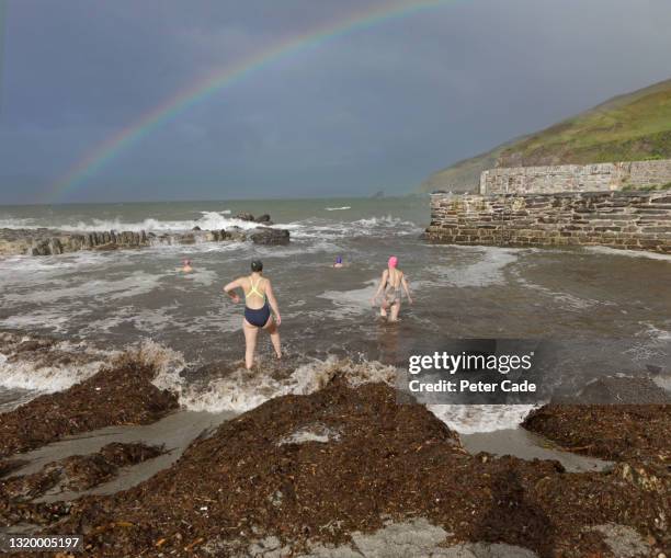 women entering cold sea for a swim - sea swimming stock pictures, royalty-free photos & images