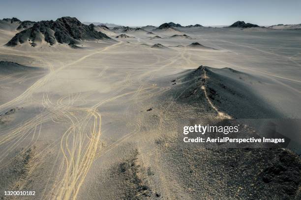 moutains and tire traces - snow covered road stockfoto's en -beelden