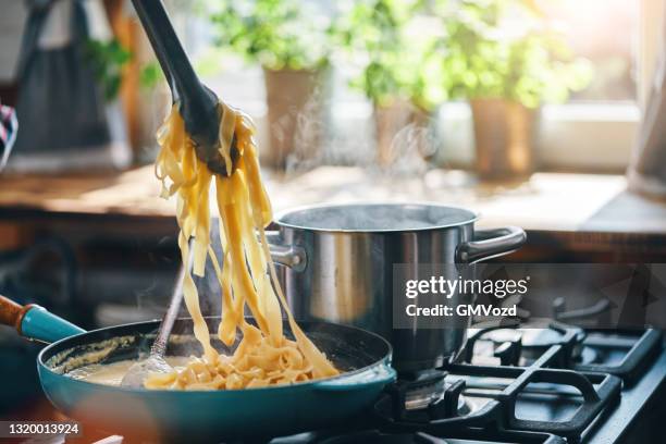 preparación de fettuccine pasta alfredo - tagliatelle fotografías e imágenes de stock