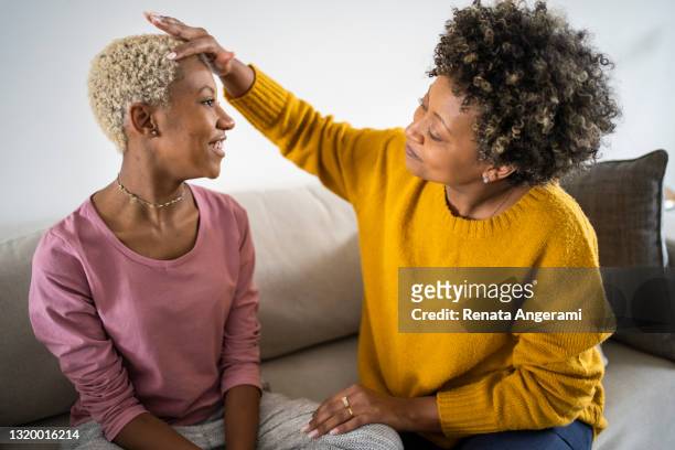 afro mother taking care of her daughter's hair - black dye stock pictures, royalty-free photos & images