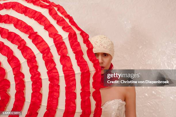 model with bizarre fashion on plain background - female fashion with umbrella stock pictures, royalty-free photos & images