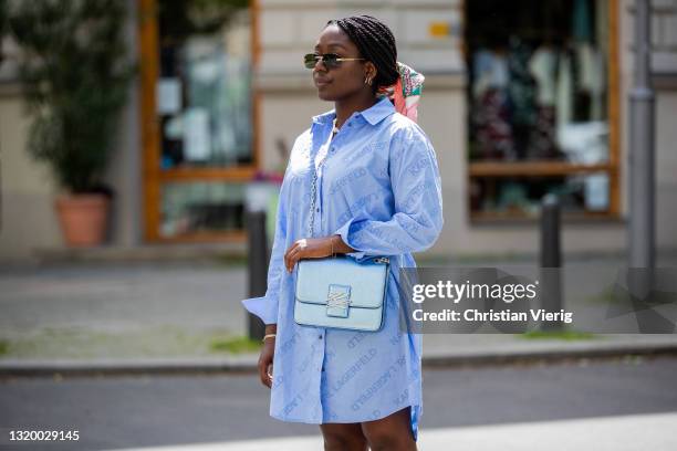 Lois Opoku is seen wearing blue oversized button shirt with logo print Karl Lagerfeld, bag Karl Lagerfeld, clogs - Bally, sunglasses Cartier, scarf...