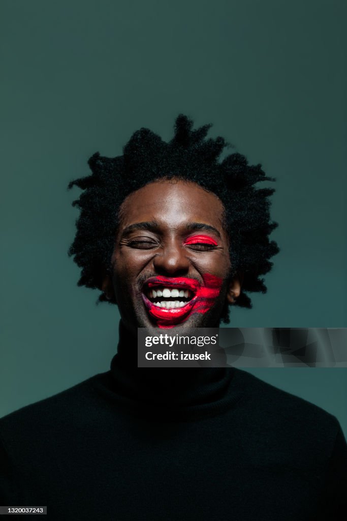 Homem com maquiagem nos olhos e lábios