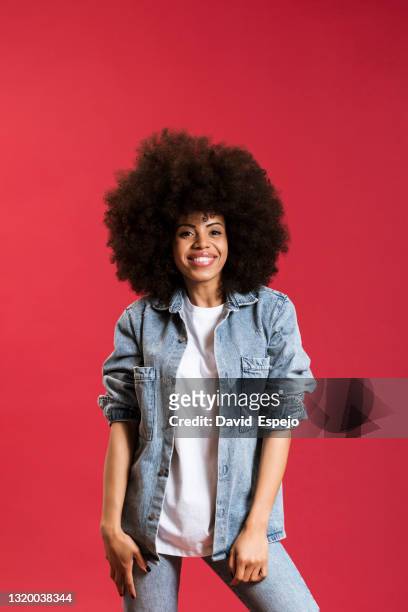 stylish black woman smiling on red background in studio - portrait femme fond rouge adulte photos et images de collection