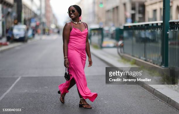 Lois Opoku wearing vintage Fendi mini bag, black Unisa heels, pink Mads Norgaard dress and Cartier shades on May 22, 2021 in Berlin, Germany.