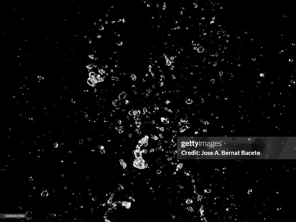 Moving water drops and splashes on a black background.