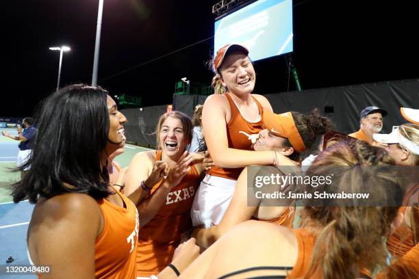 Teammates hold up Lulu Sun of the Texas Longhorns after defeating the Pepperdine Waves during the Division I Women"u2019s Tennis Championship held at...