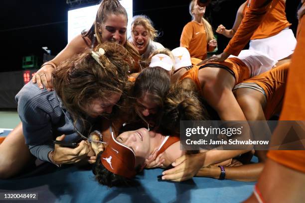 Teammates surround Lulu Sun of the Texas Longhorns after defeating the Pepperdine Waves during the Division I Women"u2019s Tennis Championship held...